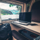 a laptop and cell phone sitting on a table with an ocean view